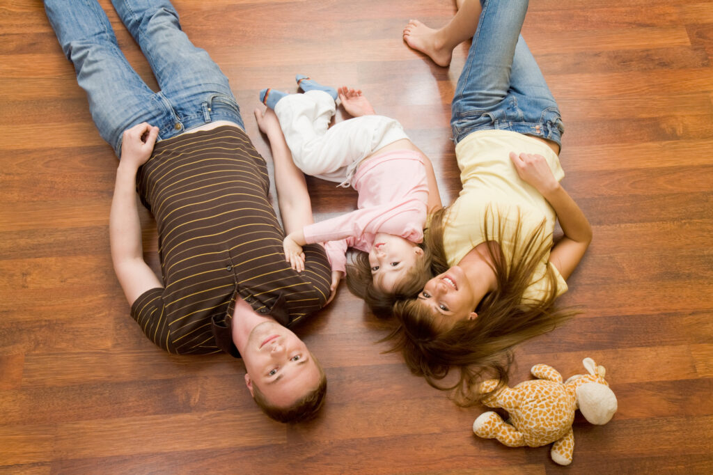 View from above of resting family lying on the floor and looking at camera