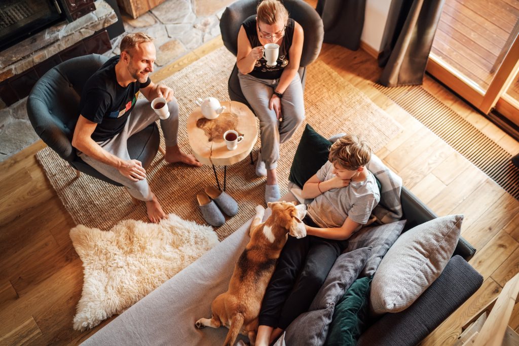 Family sitting in their cozy living room drinking coffee and enjoying the time together.